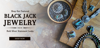 Black Jack Jewelry display with silver necklaces and pendants on a wooden surface.